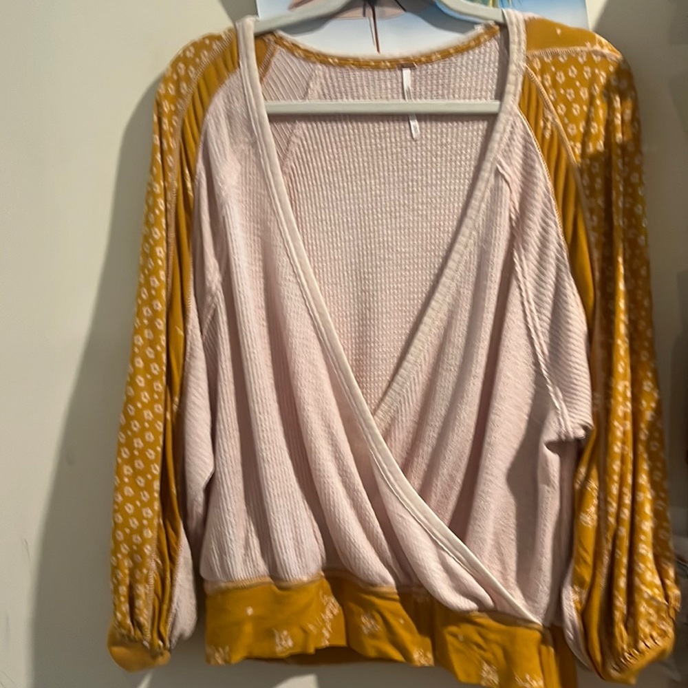This is a beautiful Free People top with floral detail on the sleeves.